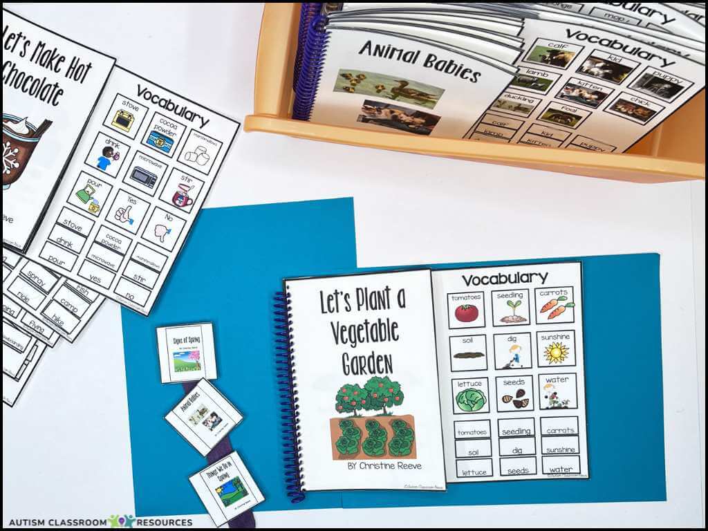 A tabletop displays educational materials, including vocabulary sheets, sorting cards, a book titled Lets Plant a Vegetable Garden, and folders—ideal for classroom learning about animals, gardening, food, and supporting reading IEP goals for nonverbal students.