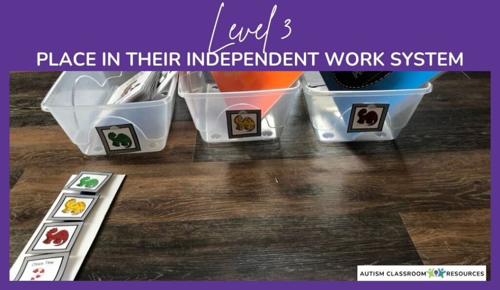 Three clear bins labeled with colored animal cards (green, yellow, red) sit on a wooden floor, with matching cards and a choice strip in front—perfect for errorless learning activities. Text reads: Level 3 Place in their independent work system.